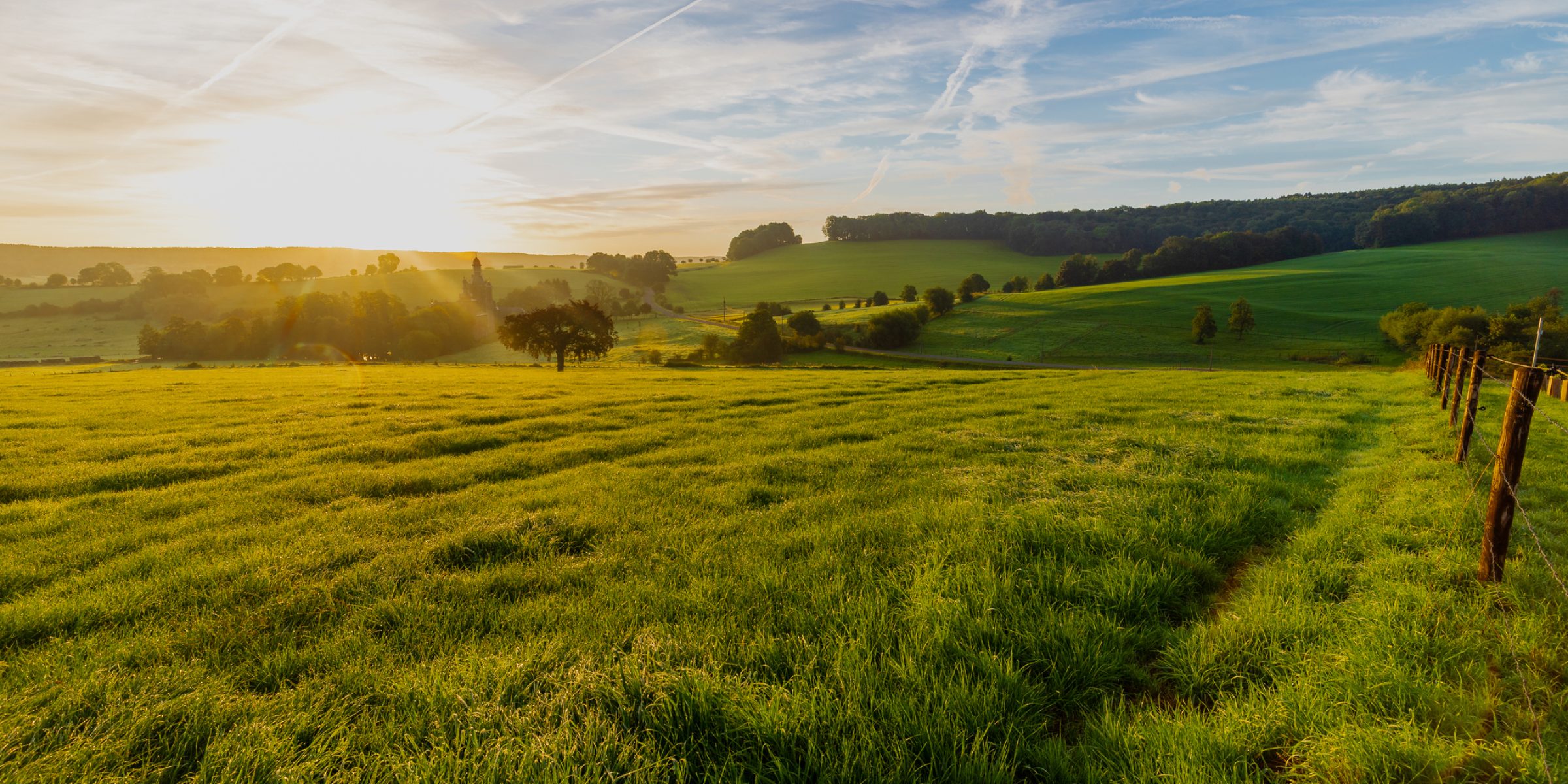 Colourful sunrise on a summer morning with a little fog on the ground and spectacular views over the Dutch hillside and the picturesque Buesdael valley which has many amazing views over the rolling hills.
